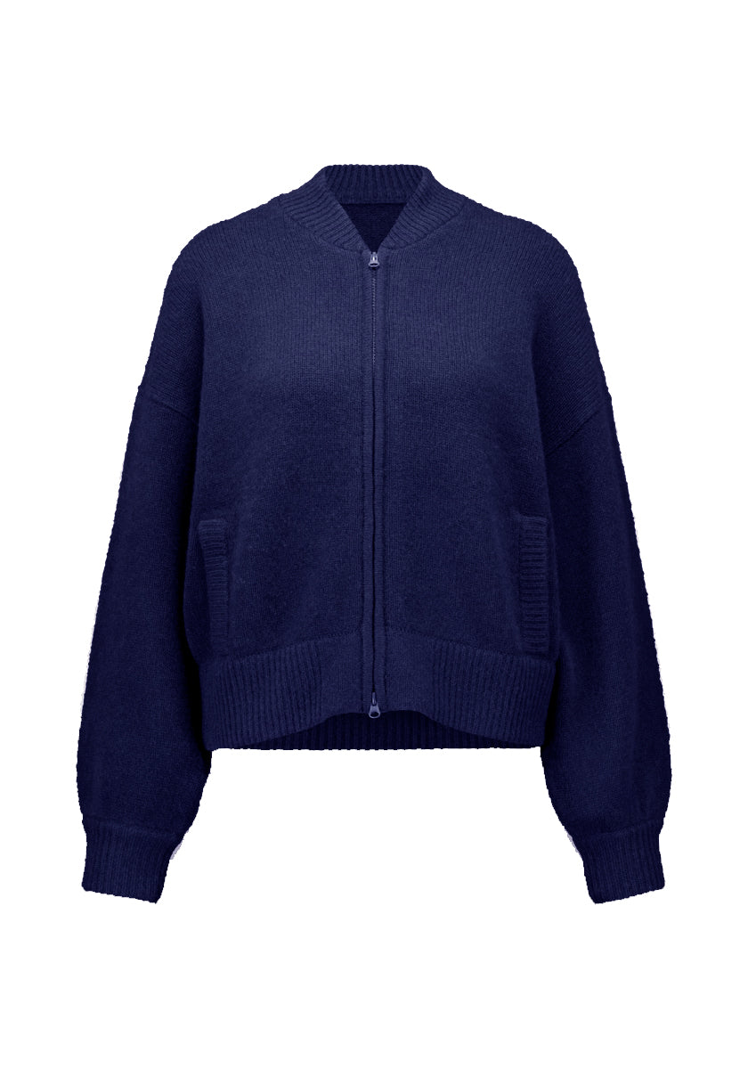 Eine marineblaue Kaschmir Strickjacke von Princess Goes Hollywood mit einem gerippten Stehkragen, Bündchen, und Saum. Sie hat einen zweiseitigen Reißverschluss, zwei gerippte Fronttaschen, lockere, leicht taillierte Passform, lange Ärmel, auf weißem Grund.