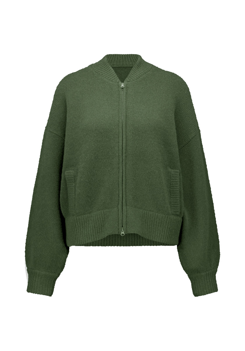 Die taillierte, olivgrüne Kaschmir Strickjacke mit Reißverschluss von Princess Goes Hollywood hat einen gerippten Stehkragen, Manschetten und Saum. Überschnittene Schultern, lange Ärmel und zwei Vordertaschen mit Rippbündchen verleihen ihr einen entspannten, gemütlichen Look.