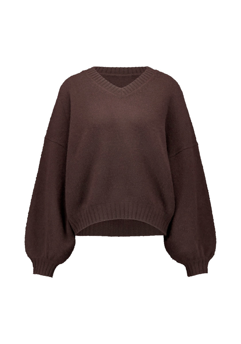 Der Princess Goes Hollywood Damen Kaschmirpullover ist ein locker sitzender dunkelbrauner V-Ausschnitt-Pullover mit langen Ballonärmeln, gerippten Bündchen und Saum, kürzerer Vorderseite, längerer Rückseite und überschnittenen Schultern, abgebildet auf weißem Grund.
