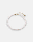 A delicate Princess Goes Hollywood Fusskette Süsswasserperlen, crafted from small white pearls with a gold lobster clasp, adjustable gold chain, and a tiny round charm, is displayed in a loose circle on a plain white background.
