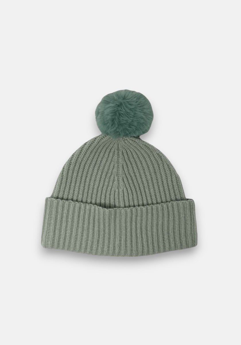 Eine sagegrüne Rippstrick-Beanie aus Wolle-Kaschmir von Princess Goes Hollywood mit breitem, gefaltetem Saum und großem flauschigem Bommel, präsentiert vor weißem Hintergrund.