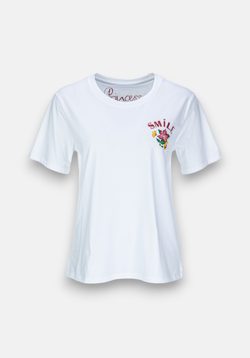 The Princess Goes Hollywood T-Shirt Smile Flower is a white cotton tee with a relaxed fit and round neckline. It features a small, colorful SMILE graphic with a yellow smiley face, red hearts, and green accents on the chest.