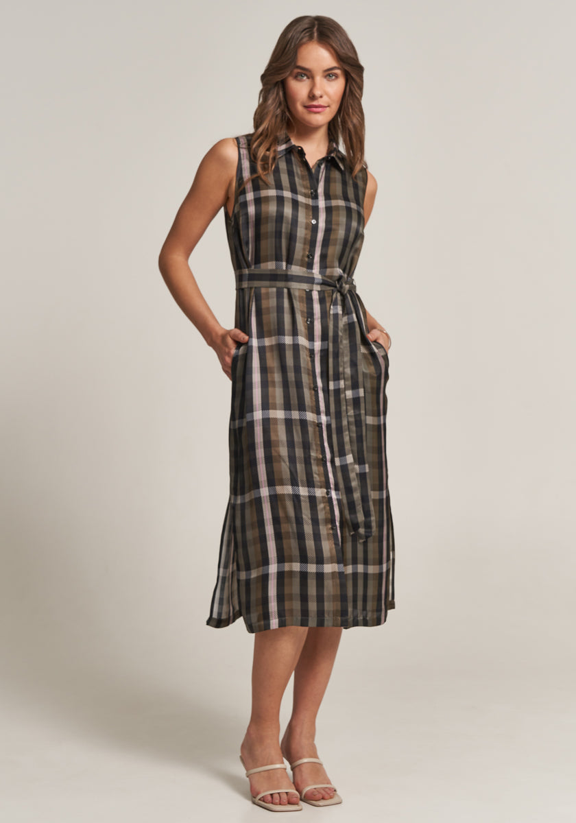 Eine Frau trägt ein ärmelloses Midikleid mit Karoprint, Hemdkragen und Gürtel von Princess Goes Hollywood in Oliv, Schwarz und Beige. Sie steht mit einer Hand in der Tasche, weißen Sandalen und hellem Hintergrund.