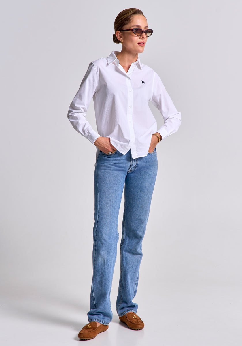 A woman wears a white Baumwollhemd by Princess Goes Hollywood with Regular Fit, light blue jeans, brown loafers, and sunglasses. She stands against a plain background, hands in her pockets, hair pulled back, looking to the side.