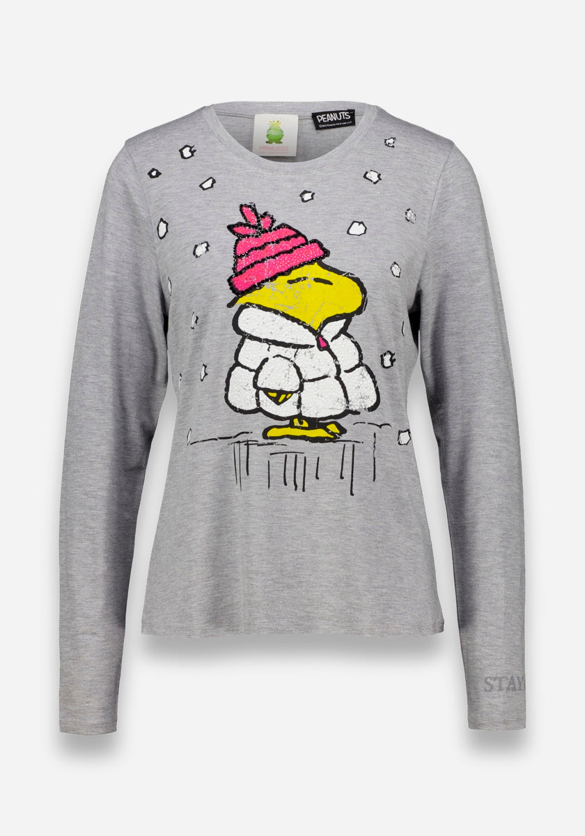 Ein graues Princess Goes Hollywood-Langarmshirt mit einem bezaubernden Peanuts-Woodstock-Aufdruck - Woodstock trägt einen rosa Hut und eine weiße Jacke inmitten von fallendem Schnee. Entspannte Passform, dezente Strass-Details und PEANUTS-Branding am Innenkragen.