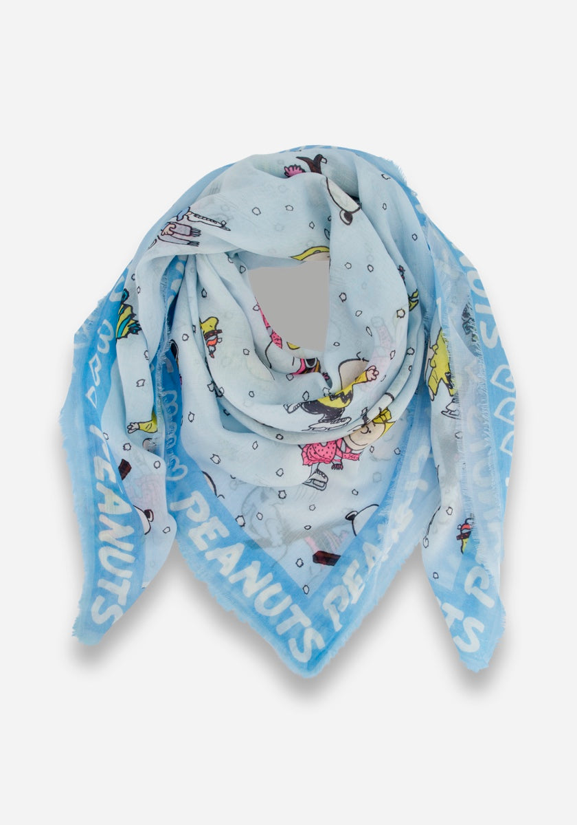 Ein hellblauer, quadratischer Schal von Princess Goes Hollywood, locker gefaltet und mit einem Winter-Snoopy-Druck mit Peanuts-Figuren, die zwischen Schneeflocken Schlittschuh laufen. Der Rand zeigt PEANUTS in fetten weißen Buchstaben und der Rand ist leicht ausgefranst.