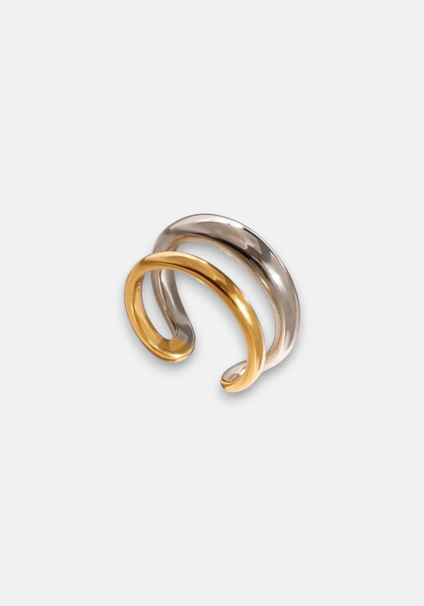 The Princess Goes Hollywood Edelstahl Ring features two intertwined, zweifarbig bands—one shiny silver and one polished gold—curved gracefully to create a minimalist, modern, and elegant design against a plain white background.