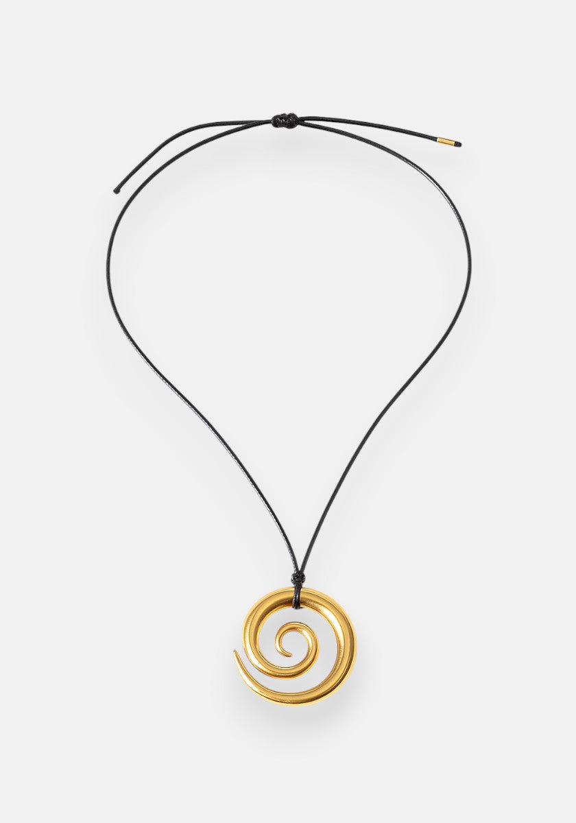 A gold spiral Edelstahl Anhänger with 18K Goldbeschichtung by Princess Goes Hollywood hangs from a simple, adjustable black cord Halskette with gold-tipped ends. The smooth, shiny pendant is set against a plain white background.