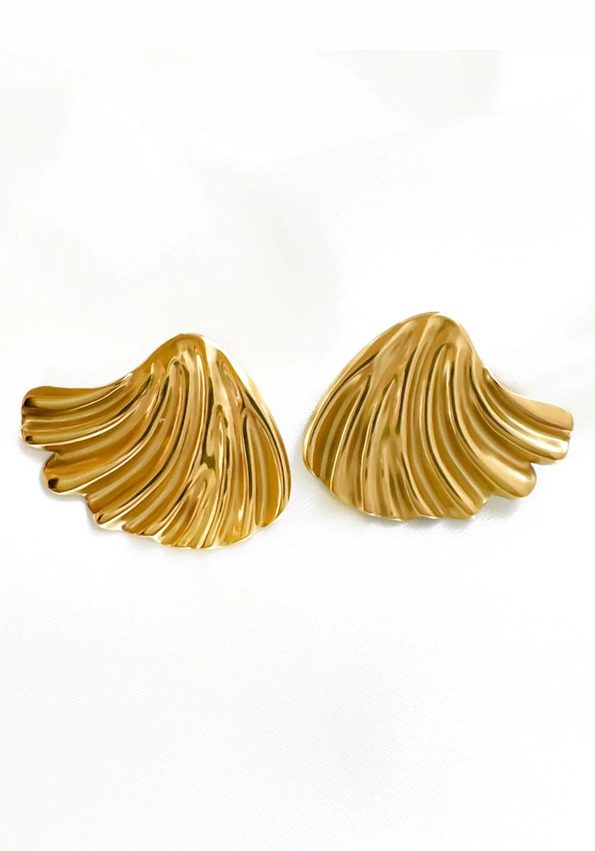 A pair of 18K gold-coated Edelstahl Ohrstecker by Princess Goes Hollywood, shaped like abstract seashells. Their wavy, textured lines and polished surface gleam softly, highlighting a sculptural design.