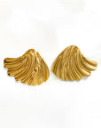 A pair of 18K gold-coated Edelstahl Ohrstecker by Princess Goes Hollywood, shaped like abstract seashells. Their wavy, textured lines and polished surface gleam softly, highlighting a sculptural design.