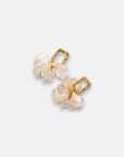 A pair of Princess Goes Hollywood earrings with gold rectangular Edelstahl hoops and dangling ruffled white iridescent Kunstperlen flower charms, shown on a plain light gray background.