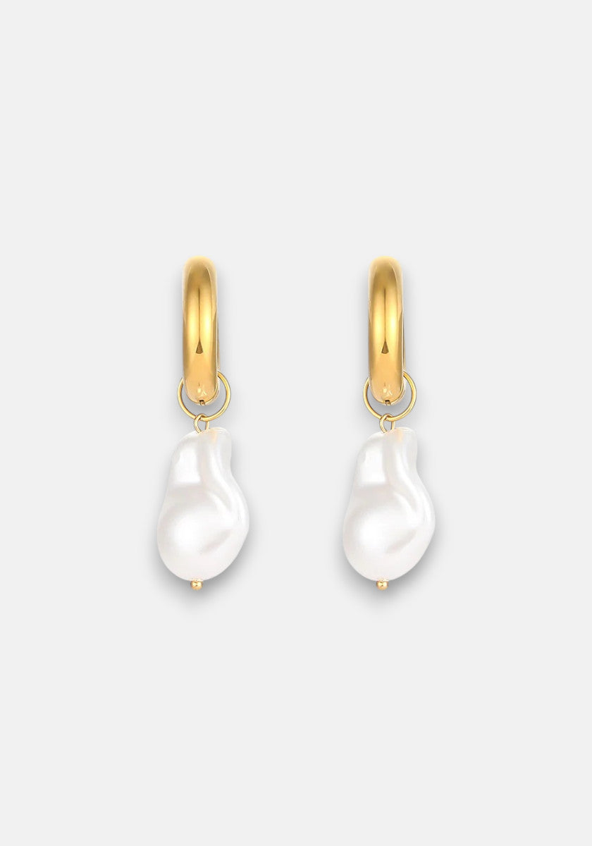 Princess Goes Hollywood 18K gold-plated stainless steel hoops each showcase a single, irregular freshwater pearl drop hanging on small gold loops, offering a modern, elegant look against a light gray background.