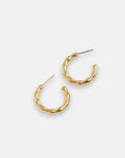 A pair of vergoldete Creolen in Bambus-Optik by Princess Goes Hollywood, featuring subtle bends and raised segments. Displayed on a white background, the elegant gold hoops have posts pointing in opposite directions.
