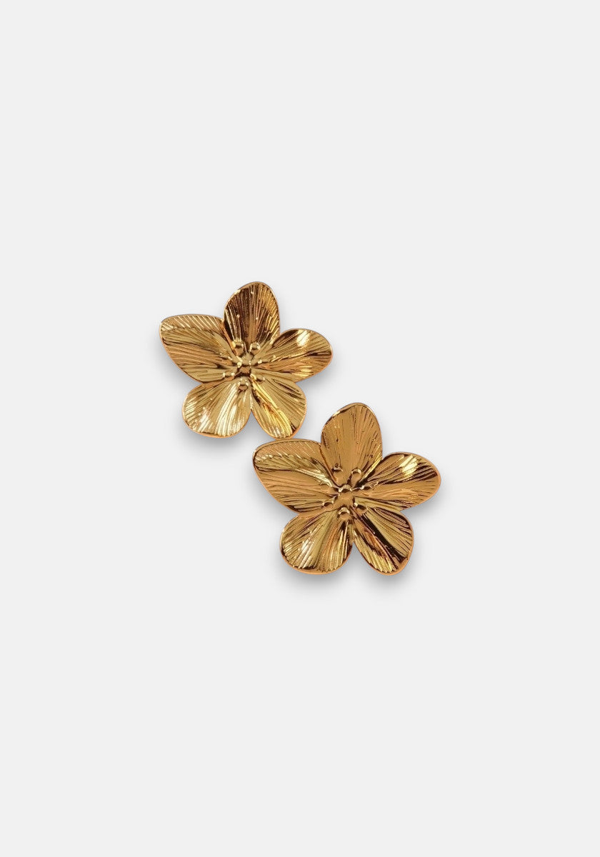 A pair of shiny, goldfarben Ohrstecker from Princess Goes Hollywood, shaped like five-petal flowers with textured lines and a natural, slightly curved design. Made from Edelstahl and displayed on a plain white background.