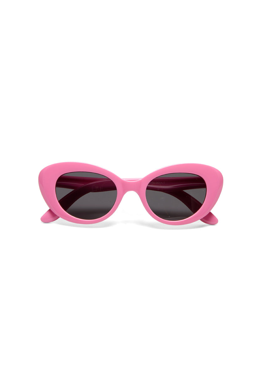 Okkia cat-eye sunglasses from the Kollektion feature bright pink frames, dark tinted lenses, and a bold retro design with thick curved edges and pointed outer tips, displayed front-facing on a white background.