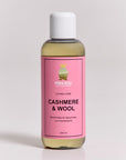 A clear plastic bottle with a white cap holds yellow liquid. Its pink label reads Princess Goes Hollywood, Loving Care Cashmere Waschmittel & Wollpflege for machine or hand wash, 240 ml.
