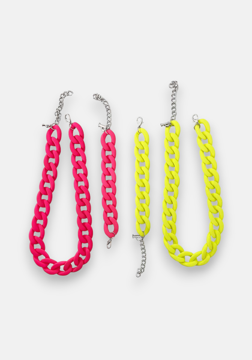 Two sets of chunky chain accessories by Princess Goes Hollywood, made from recycelter Kunststoff, are shown on a white background: a pink Halskette with bracelet on the left and a yellow set on the right. Both feature silver lobster clasps and extenders.