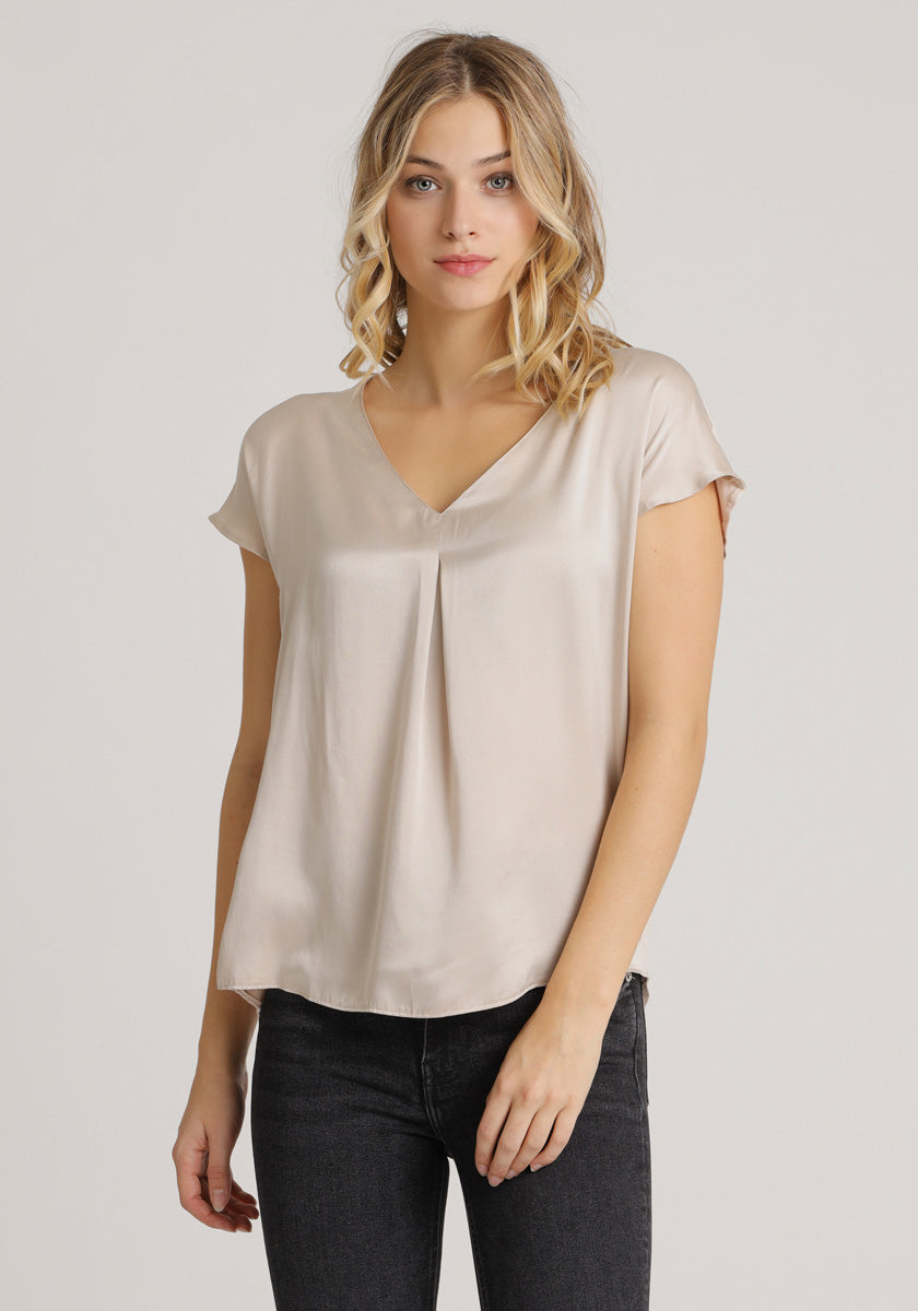 The model wears a crepe-colored silk top with a V-neck