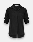 A black Bella Dahl Lyocell button-up blouse with long roll-tab sleeves, collar, two chest pockets, curved high-low hem, and a relaxed fit is shown on a plain white background.
