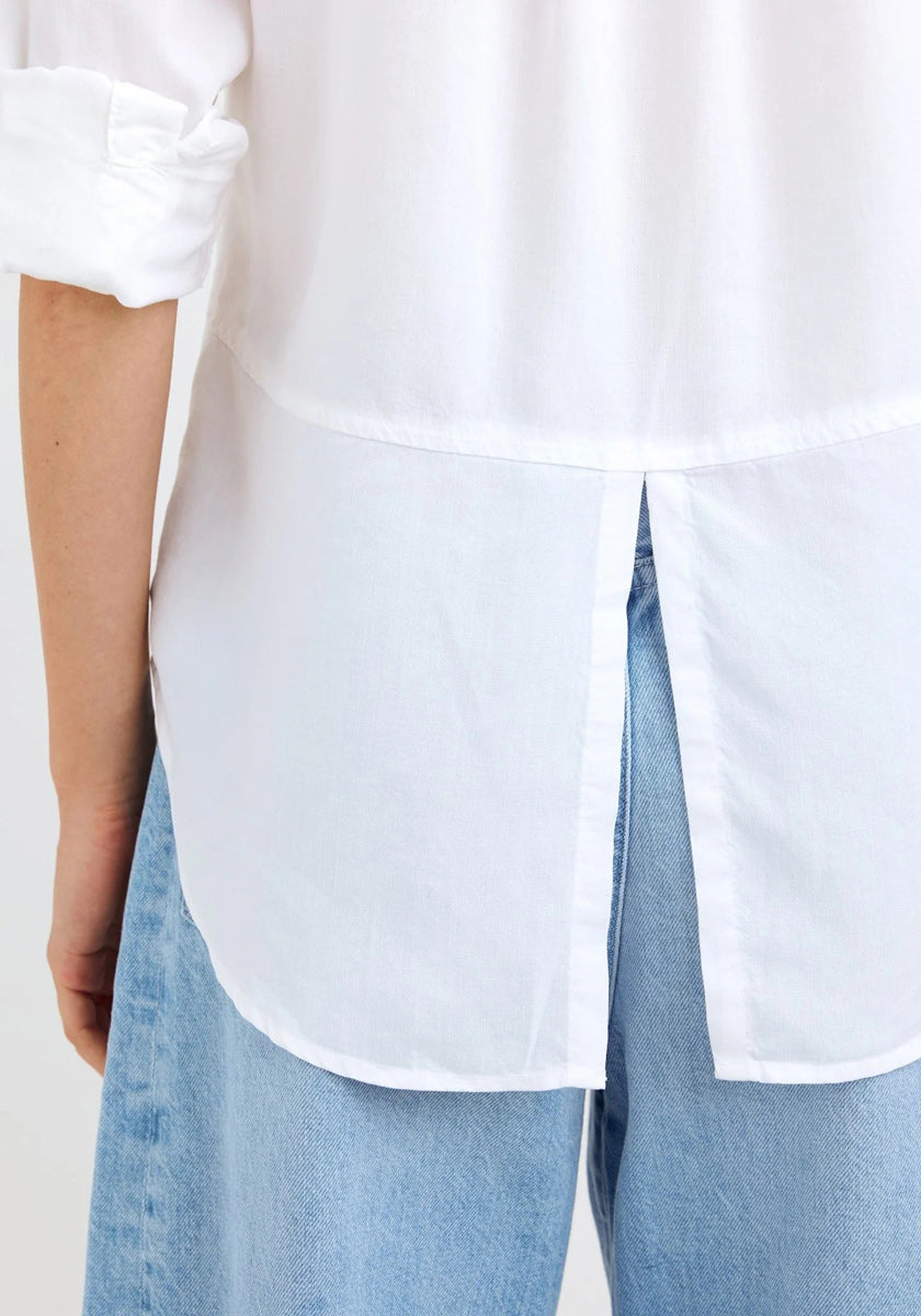 A person is seen from the back wearing a white Bella Dahl Lyocell Hemd with rolled-up sleeves and a split hem, untucked over light blue, high-waisted Jeans in Denimoptik. Only the torso and upper legs are visible.