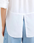 A person is seen from the back wearing a white Bella Dahl Lyocell Hemd with rolled-up sleeves and a split hem, untucked over light blue, high-waisted Jeans in Denimoptik. Only the torso and upper legs are visible.