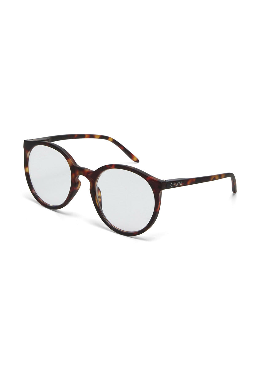 A pair of eyeglasses with round clear lenses and a brown Schildpattmuster frame, slightly curved arms, and a subtle Okkia logo on the left temple, designed for comfortable wear, displayed against a white background.