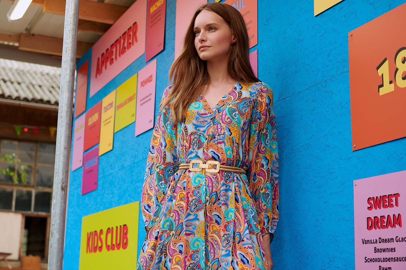 Robes d'automne portées par une femme aux cheveux roux sur fond coloré