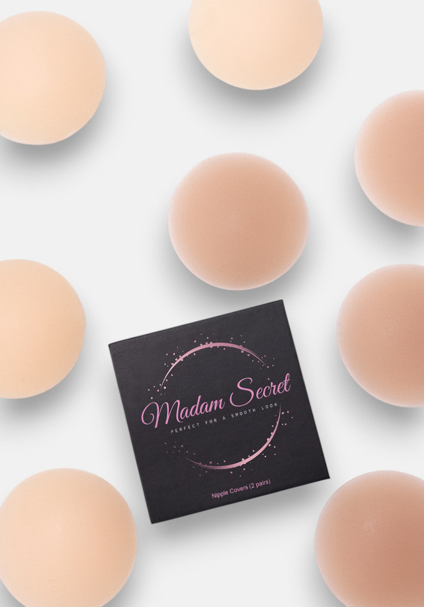 A flat lay shows a black square box labeled Princess Goes Hollywood, surrounded by eight pairs of selbstklebend Silikon Nipple Covers on a white background. The packaging features pink decorative accents and text.