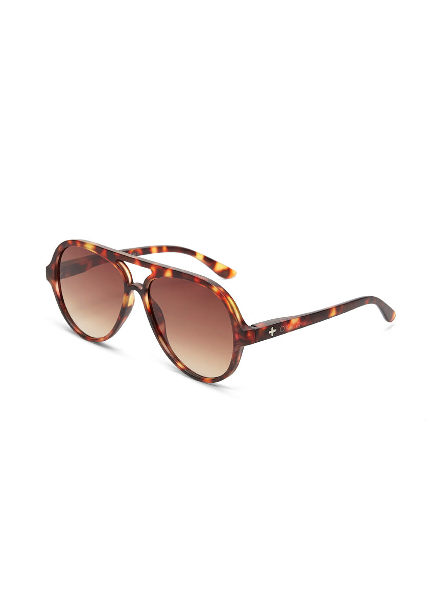 A pair of Okkia round sunglasses with a brown and amber tortoiseshell frame, gradient brown lenses, unisex design, subtle white plus sign on the arms, and UV 400 protection; angled slightly right on a white background.