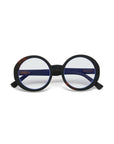 Okkia round eyeglasses with thick matte black Soft-Touch-Material frames and blue-tinted lenses. Oversize design with dark arms, featuring a hint of tortoiseshell at the hinges, displayed on a plain white background.