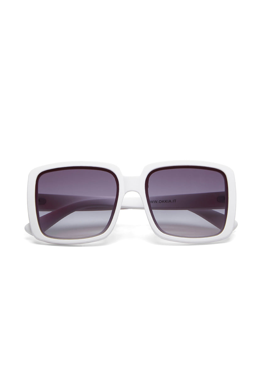 Front-facing view of Okkia Oversize-Stil Sonnenbrille, featuring a thick white frame and dark gradient lenses with UV 400-Schutz. The left inner arm displays a small black website URL. Set against a plain white background.
