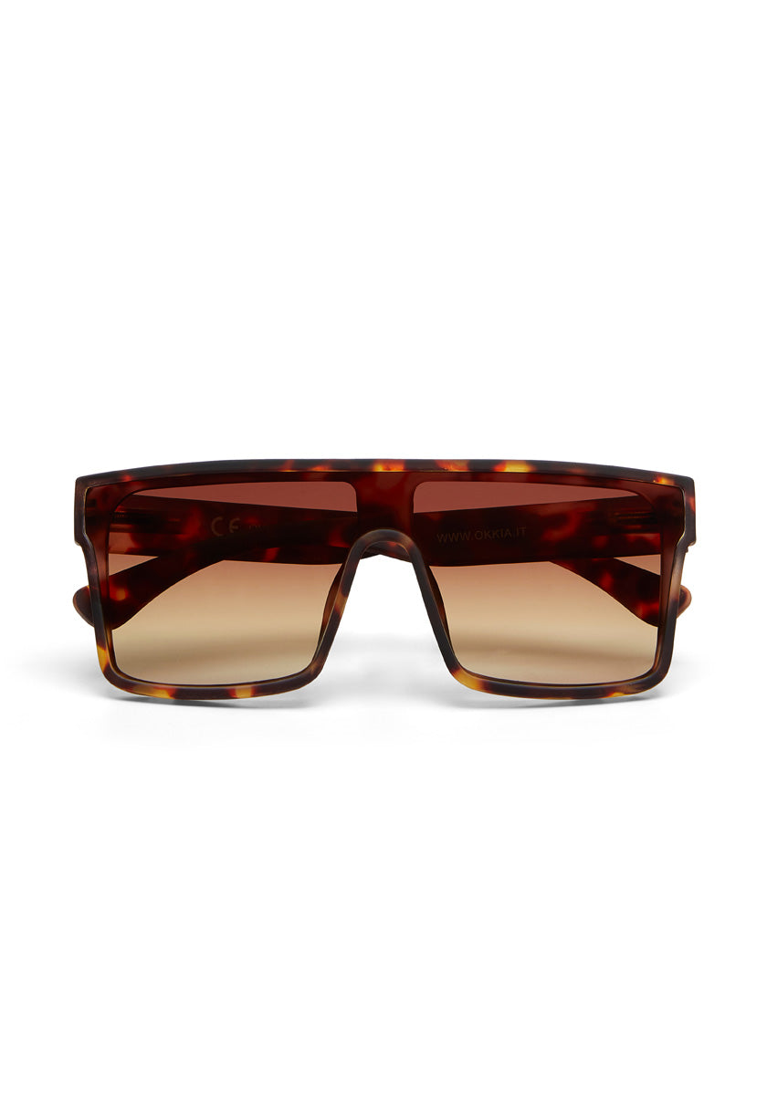 Rechteckige Sonnenbrille von Okkia mit dicken, braun-melierten Oversized-Rahmen und großen, braun verlaufenden Gläsern. Bietet UV 400-Schutz und überzeugt durch breite, flache Brücke für einen modernen Statement-Look.