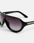 Nahaufnahme einer schwarzen Sonnenbrille von Okkia mit breitem, abgerundetem Rahmen und polarisierten Gläsern in einem Farbverlauf von dunklem zu hellem Violett. Der linke Bügel ist mit einem metallischen Akzent versehen, in den der Markenname eingraviert ist. Vor einem schlichten weißen Hintergrund unterstreicht diese elegante, moderne Sonnenbrille das minimalistische Design von Okkia.