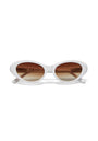 A pair of Okkia sunglasses featuring a thick white oval frame, brown gradient lenses, and a retro cat-eye design. The straight arms have curved ends, all set against a plain white background.