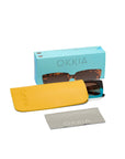 A pair of Okkia sunglasses with tortoiseshell frames sits partly in a bright yellow case. In front is a gray microfiber cloth with Okkia branding, and behind them is a blue Okkia box. All items are displayed on a white background.