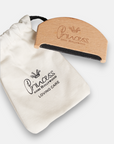 A wooden grooming comb from Princess Goes Hollywood, made of beechwood and engraved with the brand name, rests on a white drawstring pouch labeled Princess Goes Hollywood LOVING CARE, both set against a light background.
