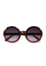 Okkia round sunglasses with oversized frames feature a tortoiseshell pattern on the top and outer edges, blending into translucent red at the bottom. The dark gradient lenses fade from black to light gray.