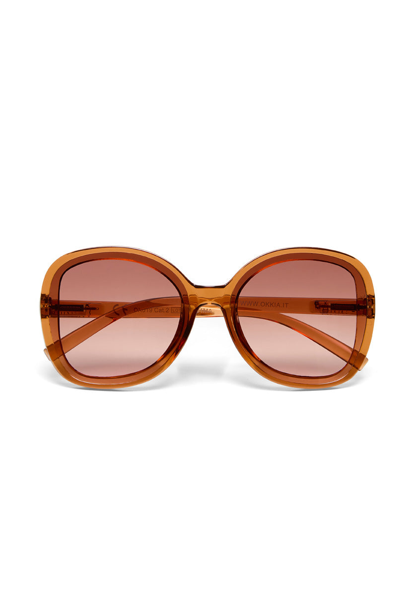 Front view of oversized, square Okkia ANNA Sonnenbrille in bold Butterfly-Stil with thick amber-orange translucent frames, brown gradient UV-Schutz lenses, and slightly visible amber arms. Shown on a white background.
