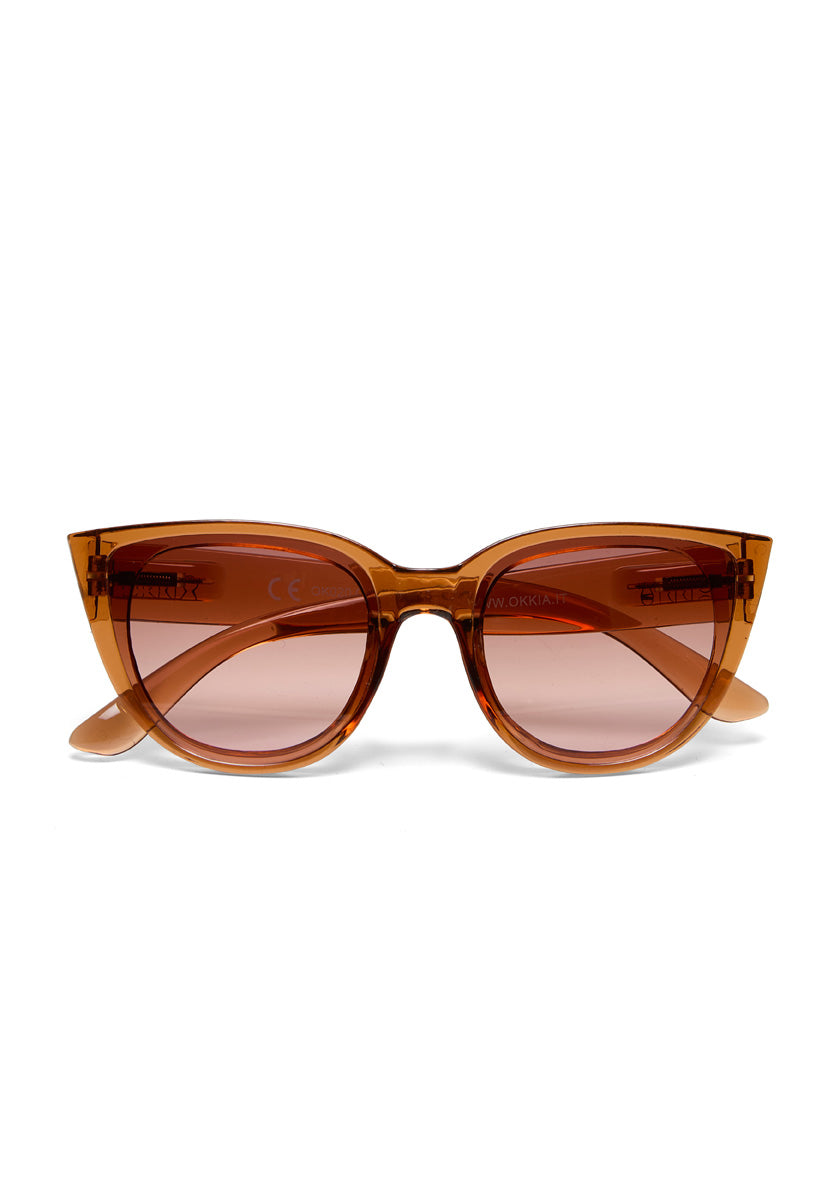Front view of Okkia brown Cat-Eye sunglasses with thick, glossy frames and lightly tinted brown lenses offering UV protection. Gently curved arms are shown against a plain white background.