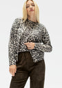 Ein Model mit glattem blondem Haar trägt eine grau-schwarze Leo-Print Kaschmir Strickjacke und ein dazu passendes Oberteil von Princess Goes Hollywood, gepaart mit einer hochtaillierten dunkelbraunen Wildlederhose, vor einem schlichten weißen Hintergrund.