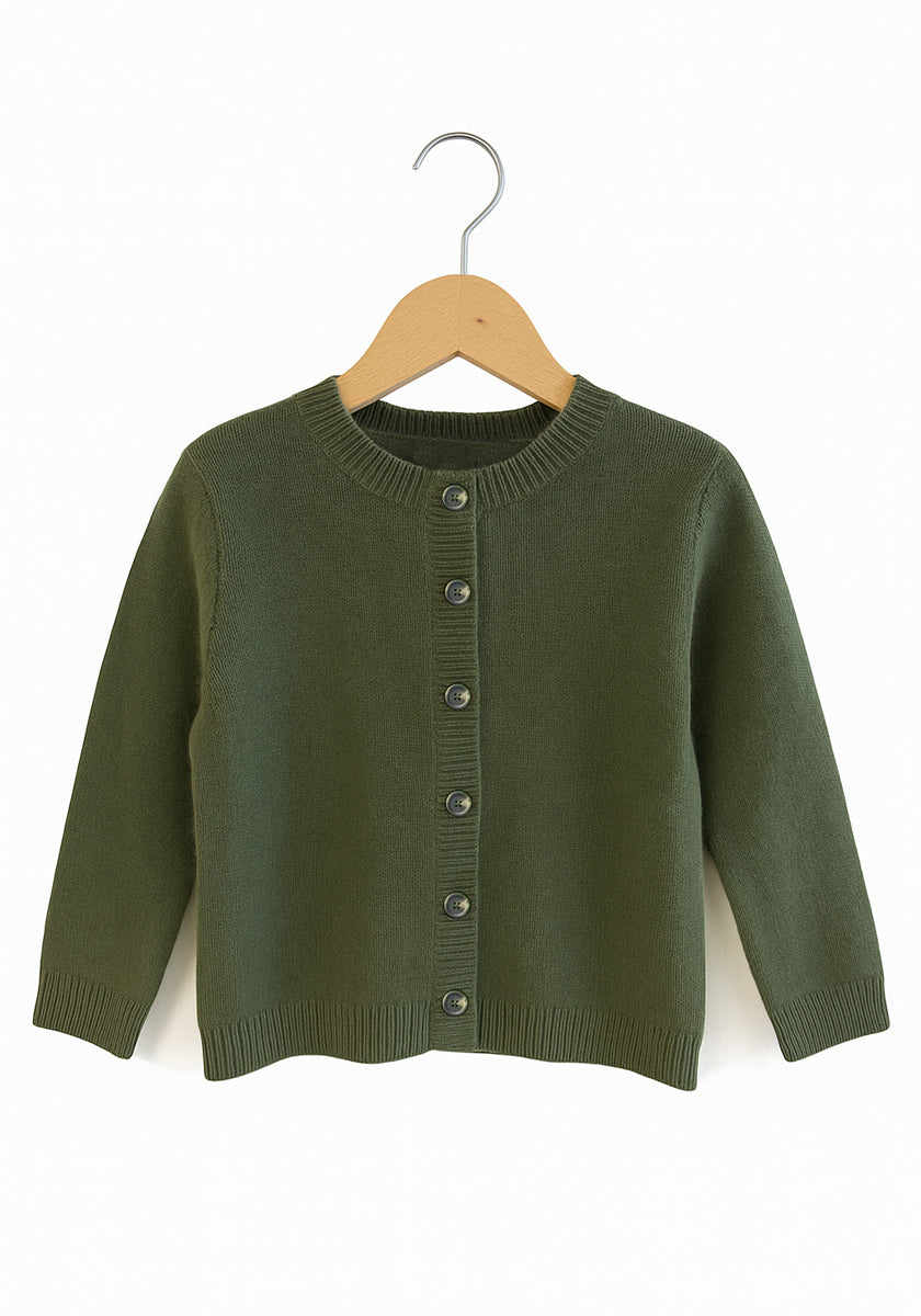 Eine grüne Princess Goes Hollywood Kaschmir Strickjacke Kinder auf einem Swinger, perfekt für gemütliche Tage und verspielte Momente.