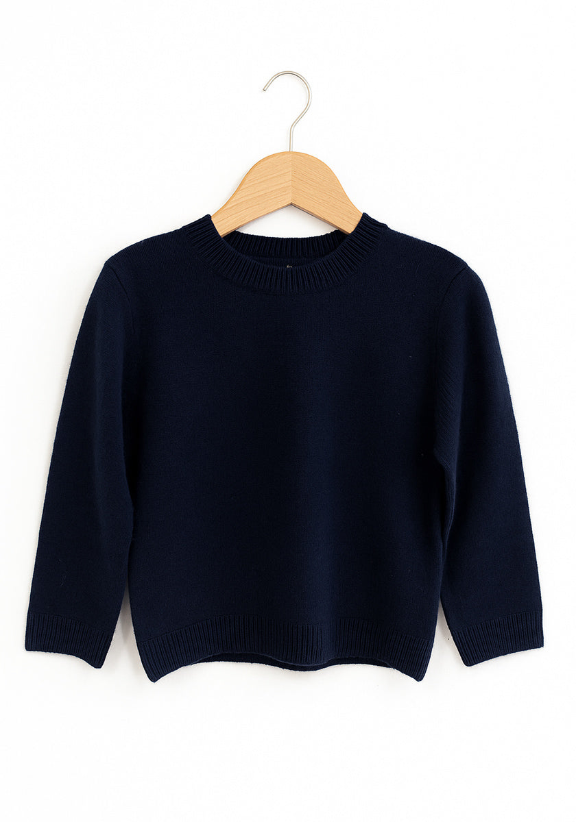 Ein dunkelnavyblauer Princess Goes Hollywood Kaschmir Strickpullover Kinder mit langen Ärmeln hängt auf einem hellen Holzbügel vor einem schlichten weißen Hintergrund und verfügt über einen gerippten Rundhalsausschnitt, Manschetten und Saum für einen klassischen Look.