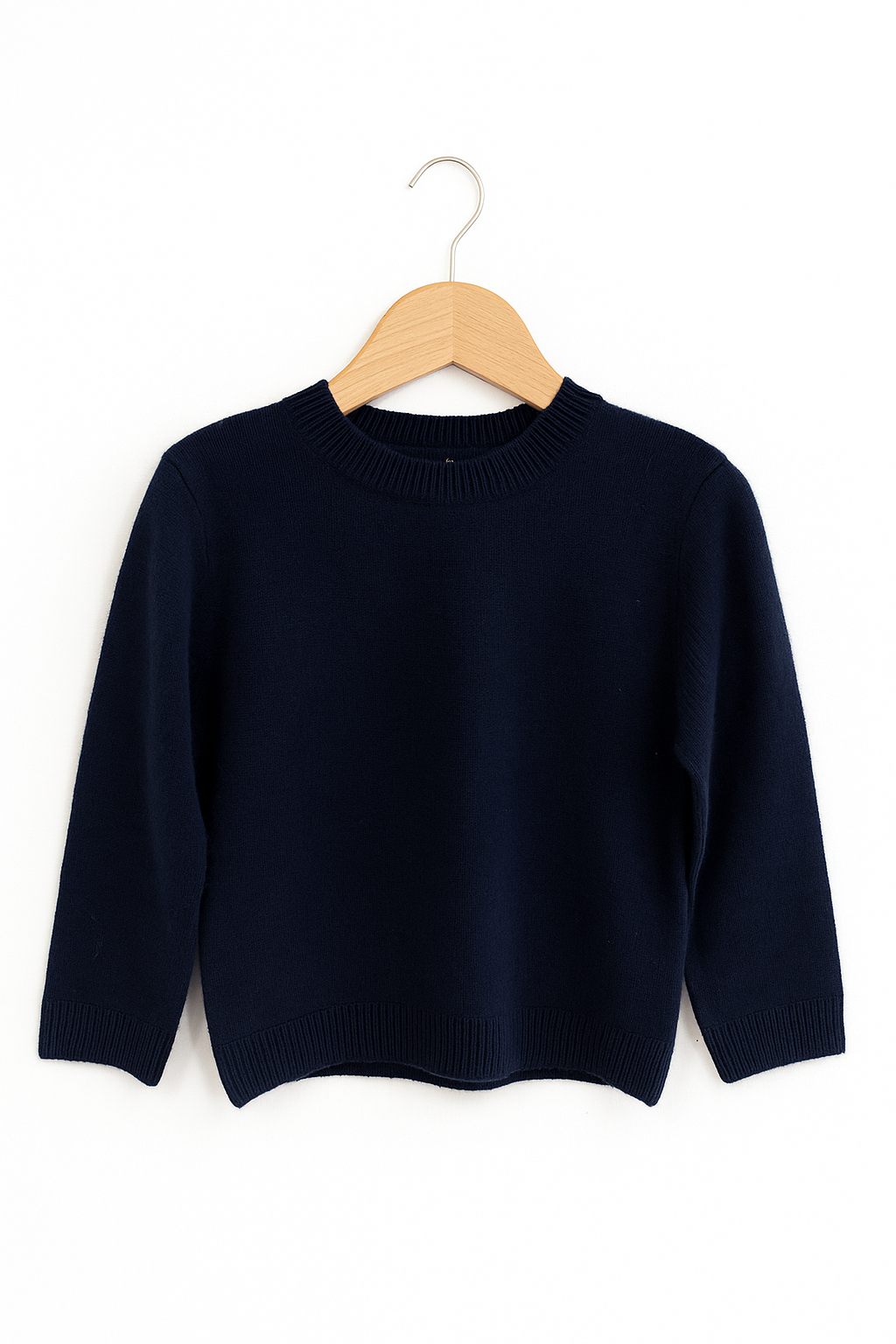 Ein dunkelnavyblauer Princess Goes Hollywood Kaschmir Strickpullover Kinder mit langen Ärmeln, Rundhalsausschnitt und gerippten Bündchen, Hals und Saum wird auf einem Holzbügel vor einem weißen Hintergrund präsentiert. Die Größe ist perfekt für Kinder.
