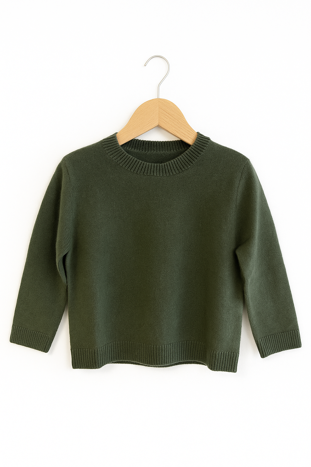 Ein waldgrüner Princess Goes Hollywood Kaschmir Strickpullover Kinder mit Rundhalsausschnitt hängt an einem hellen Holzbügel. Der langärmelige Pullover aus 100% Kaschmir hat Rippenbündchen, Kragen und Saum für einen klassischen Look.
