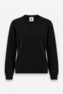 Ein schwarzer, langärmeliger Kaschmirpullover mit V-Ausschnitt. Auf dem Innenetikett ist über dem Wort PRINCESS eine Illustration eines grünen Frosches mit einer Krone abgebildet.