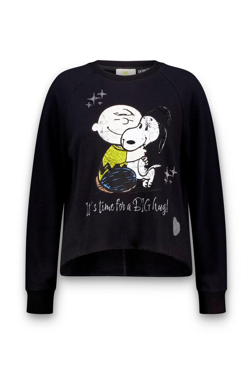 Dieses schwarze Snoopy-Sweatshirt zeigt Charlie Brown, wie er Snoopy umarmt – beide lächeln mit geschlossenen Augen. Silberne Sterne und Strasssteine verleihen der fröhlichen Illustration einen Hauch von Glanz, ergänzt durch den Schriftzug „It’s time for a BIG hug!“. Das Sweatshirt ist aus weicher Baumwolle gefertigt und verfügt über lange Ärmel sowie einen leicht abgerundeten, vorne kürzeren Saum für eine bequeme Passform.