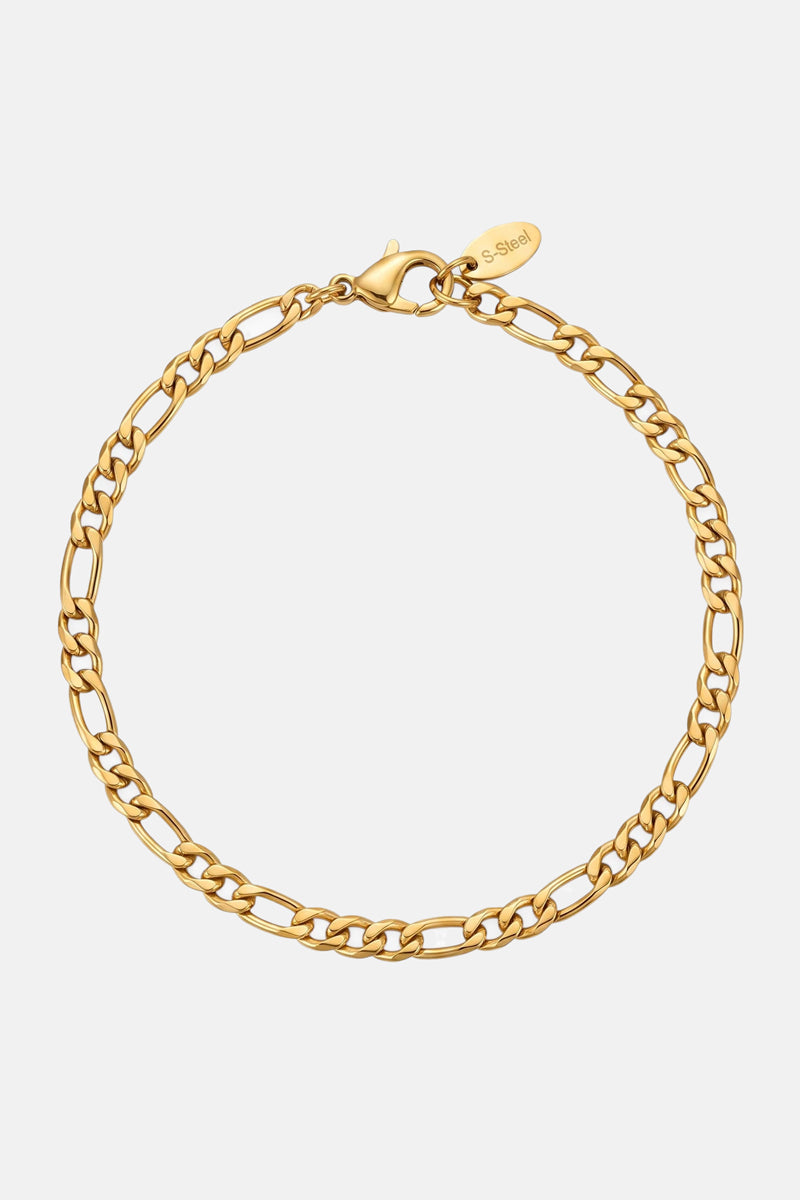 Ein goldfarbenes Edelstahl-Armband von Princess Goes Hollywood mit länglichen, eng aneinanderliegenden ovalen und rechteckigen Gliedern und einem Karabinerverschluss. Auf einem kleinen goldenen Anhänger in der Nähe des Verschlusses ist „S. Steel“ eingraviert. Abgebildet auf einem schlichten weißen Hintergrund.
