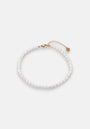 A delicate Princess Goes Hollywood Fusskette Süsswasserperlen, crafted from small white pearls with a gold lobster clasp, adjustable gold chain, and a tiny round charm, is displayed in a loose circle on a plain white background.