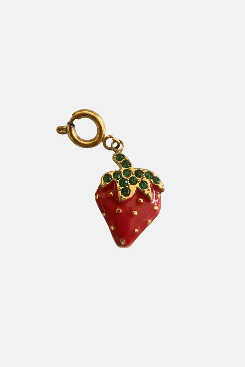 Ein goldfarbener „Erdbeer“-Anhänger von Princess Goes Hollywood in Form einer Erdbeere, mit roter Emaille, goldenen Punkten und grünen Kristallblättern – ein elegantes Armband-Accessoire aus Edelstahl auf schlichtem weißem Hintergrund.