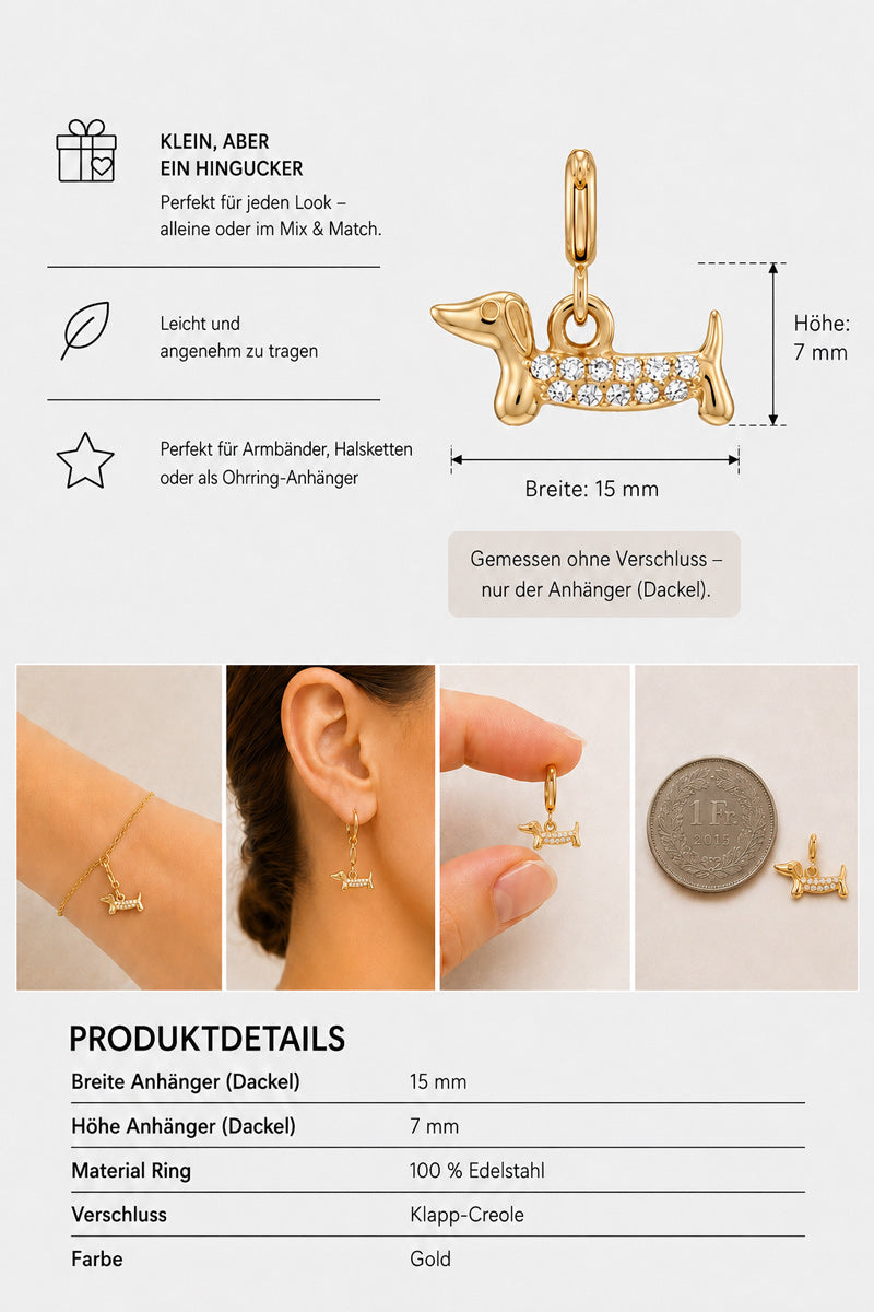 Goldener Dackel-Anhänger mit kleinen weißen Steinchen von Princess Goes Hollywood, daneben eine 2-Euro-Münze, als Ohrring gestylt. Dieser bezaubernde Dackel-Charm ist als Edelstahl-Anhänger gefertigt – ein ideales Geschenk für Hundefans. Die Abbildung veranschaulicht die Größe des Anhängers: 15 mm breit und 7 mm hoch. Informationstext und Symbole heben wichtige Details und Produktmerkmale hervor.